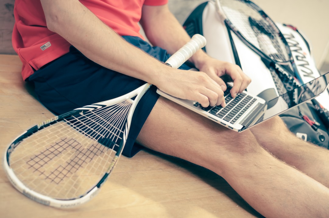 An athlete in kit using a laptop between training sessions